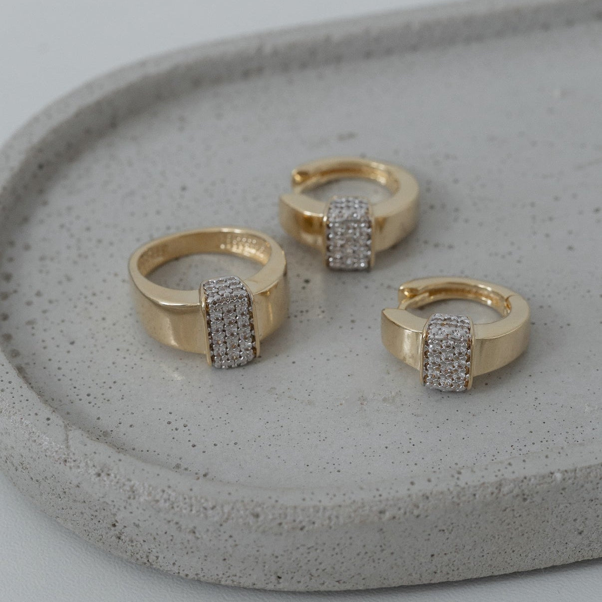 Gold rings with gemstones on a gray stone surface